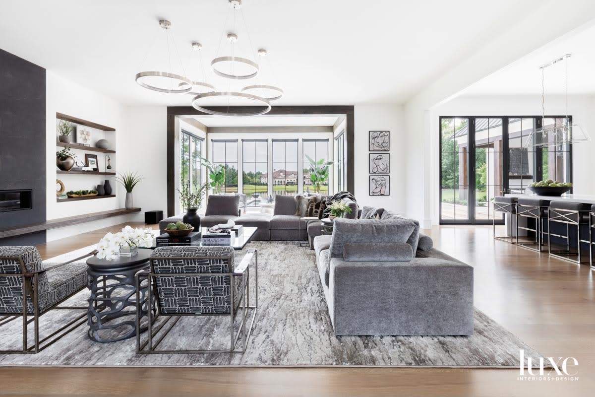 Light-filled family room with gray upholstery and ring-shaped light fixtures