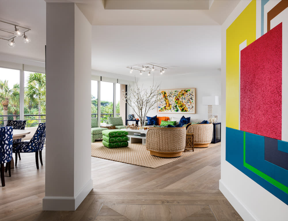 A vibrant painting adorns the living room wall, adding a splash of color to the cozy interior space with European oak flooring.