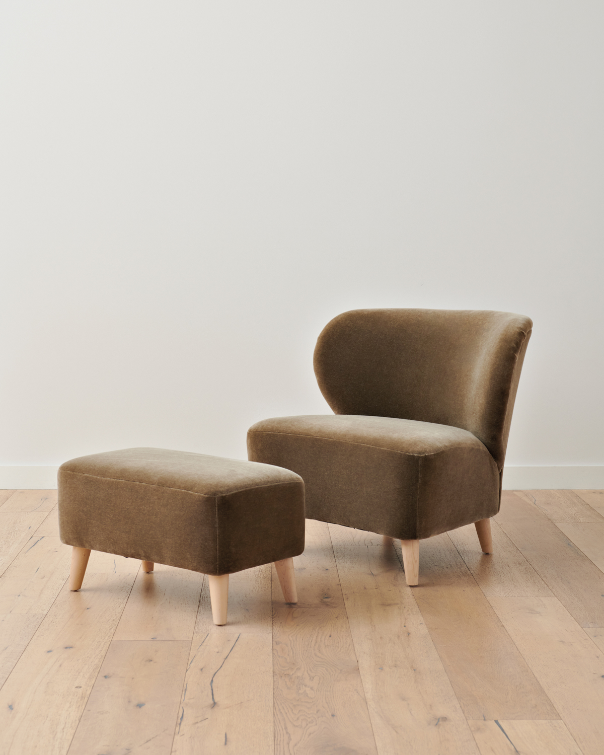 Jenni Kayne chair and matching ottoman in Olive Mohair atop blond wood floors