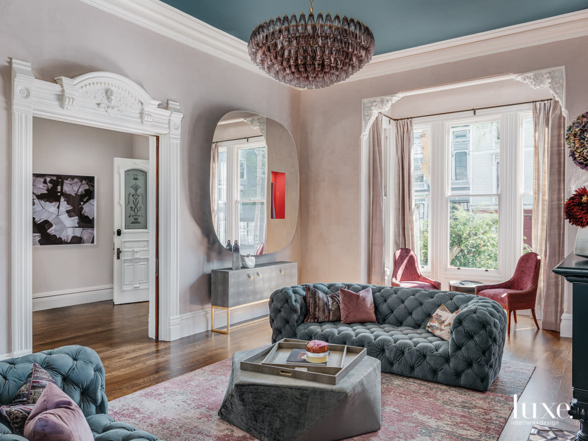 living room with big mirror, arch doors and blue couch