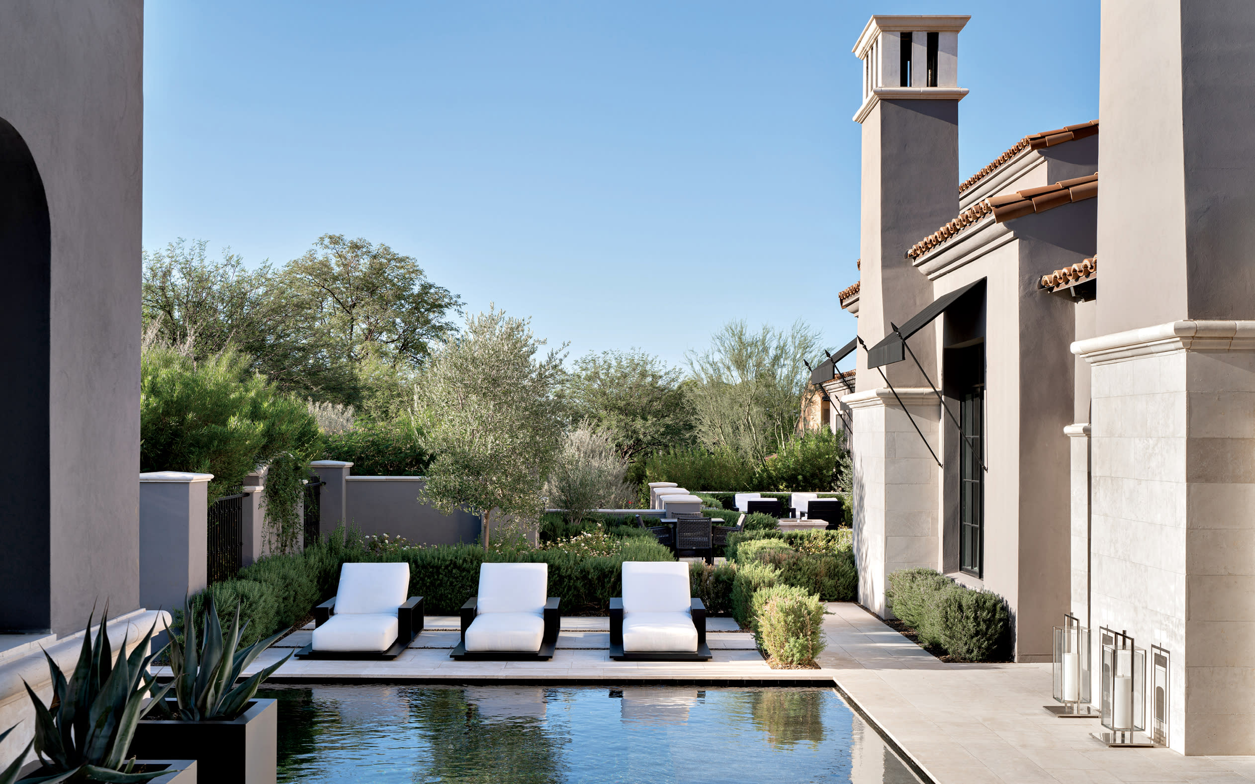 luxurious backyard with a black-hued pool surrounded by loungers at an Arizona home