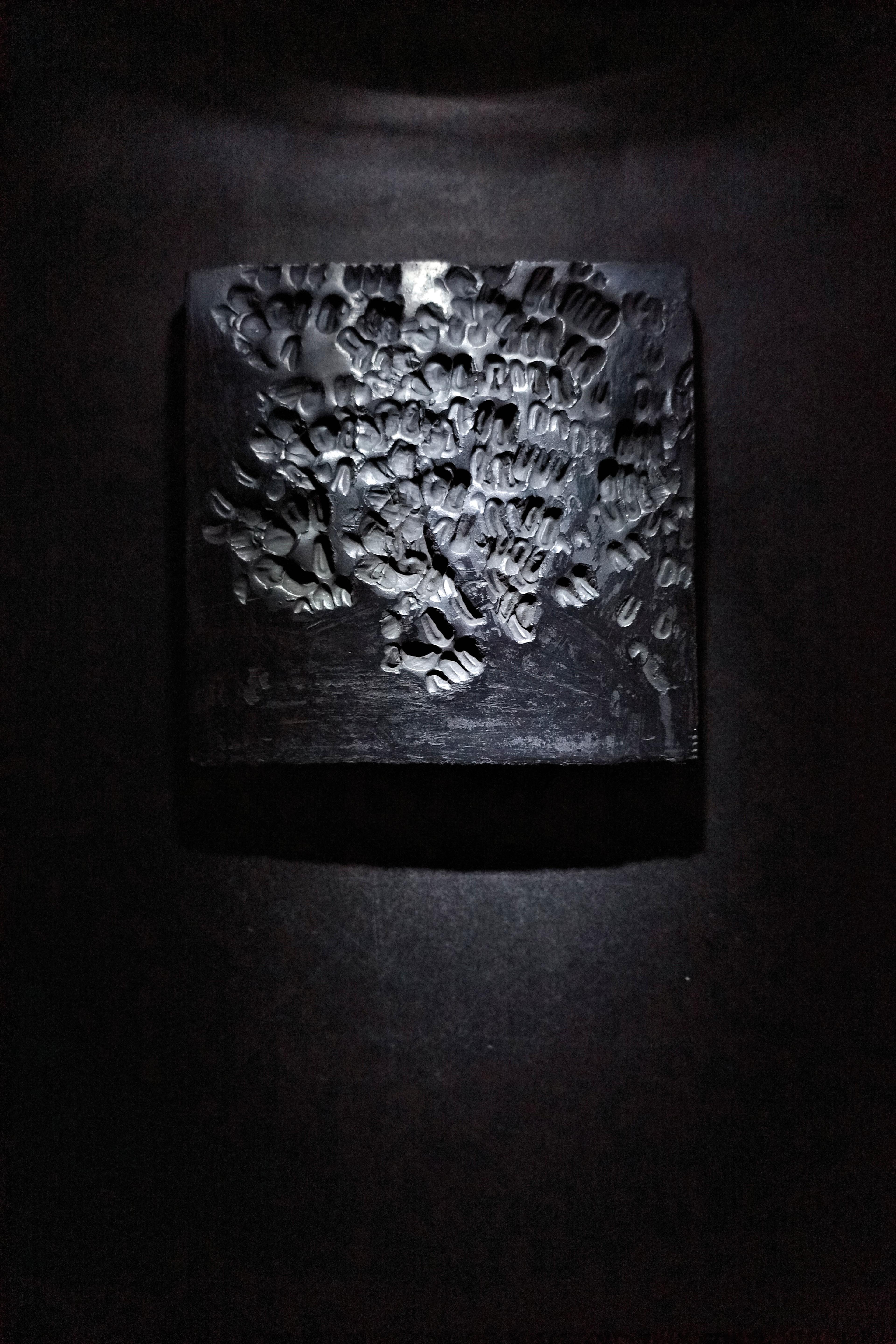 black textural tile under a spotlight