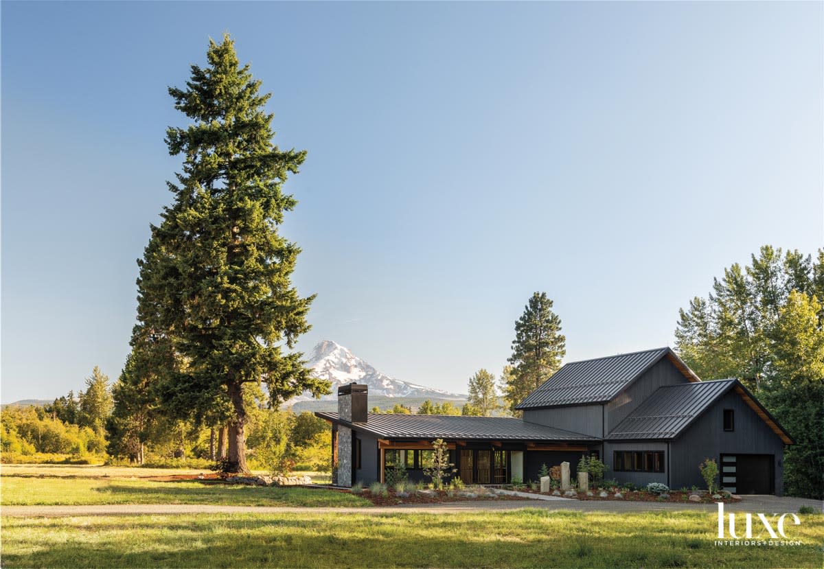 House with black siding and mountain in the distance