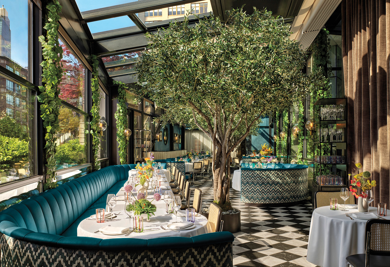 Twenty Three Grand with blue-velvet rounded banquette, checkered marble flooring and indoor trees