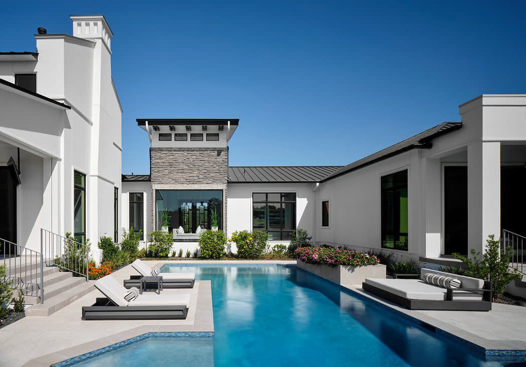 Backyard with in-ground pool and loungers.