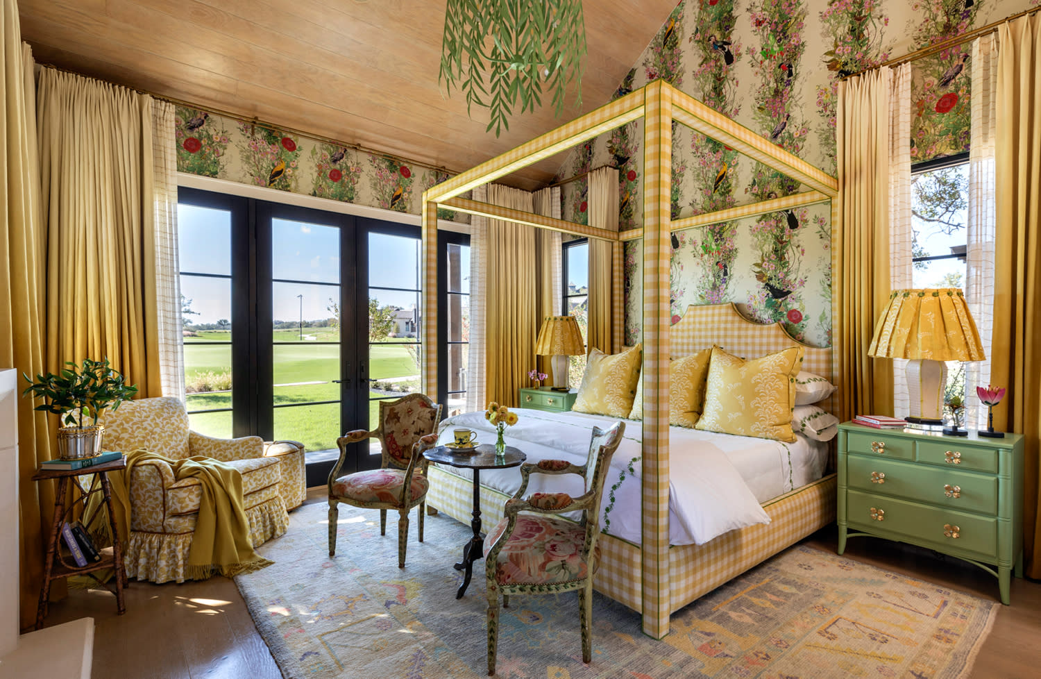 Elegant bedroom with floral wallpaper and a patterned canopy bed. 