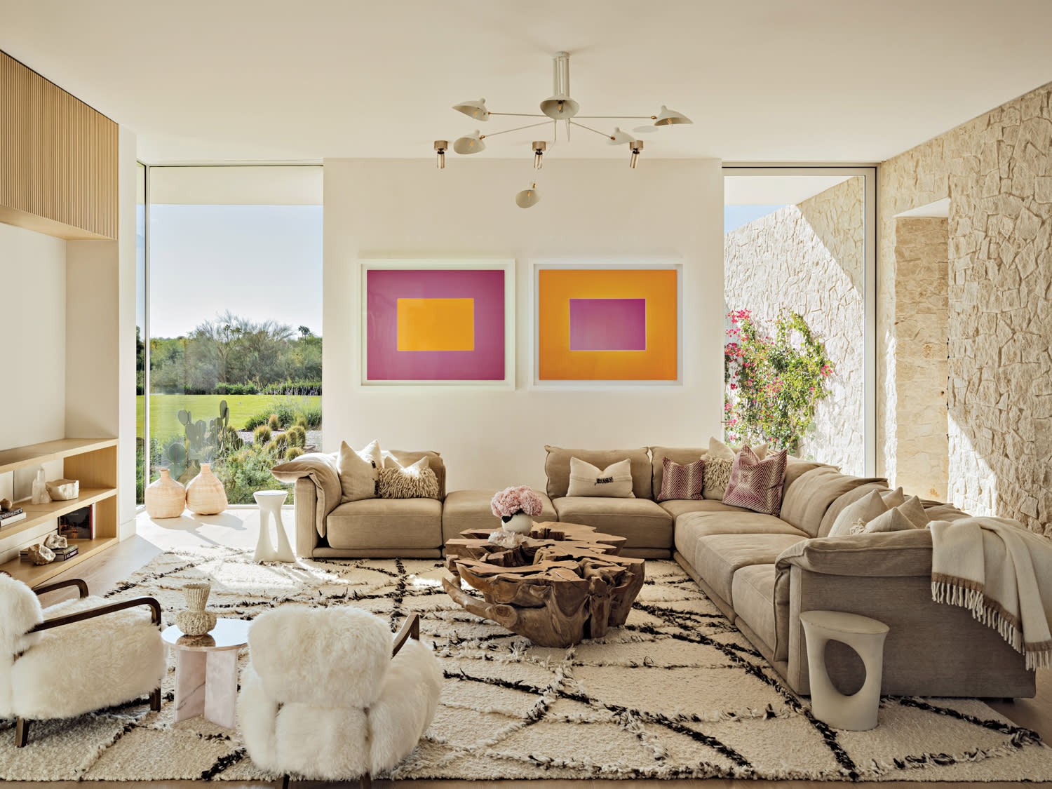 contemporary family room with pink and orange artwork and neutral furnishings