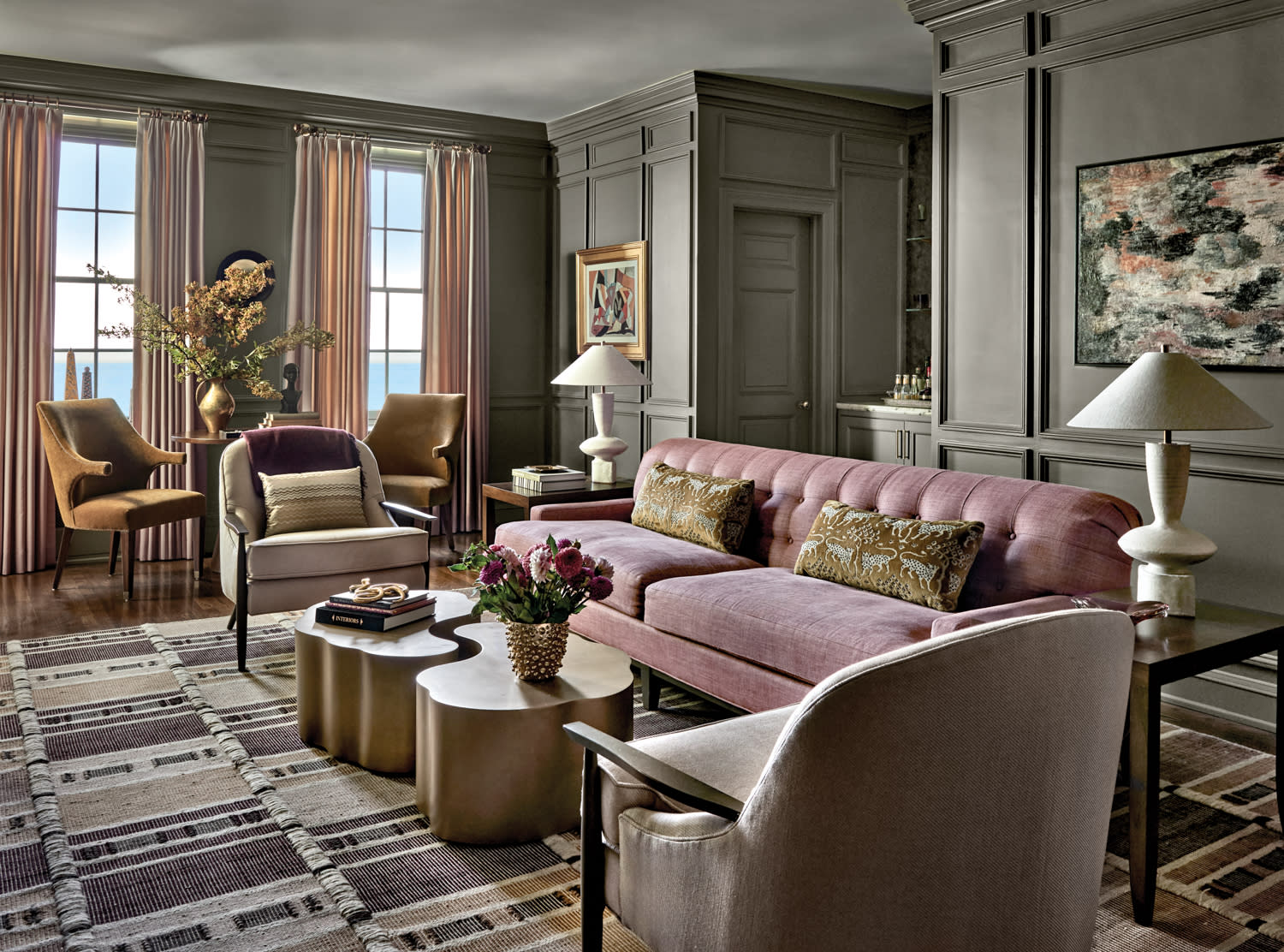 classic library room in a Chicago home with light green walls and a pink sofa