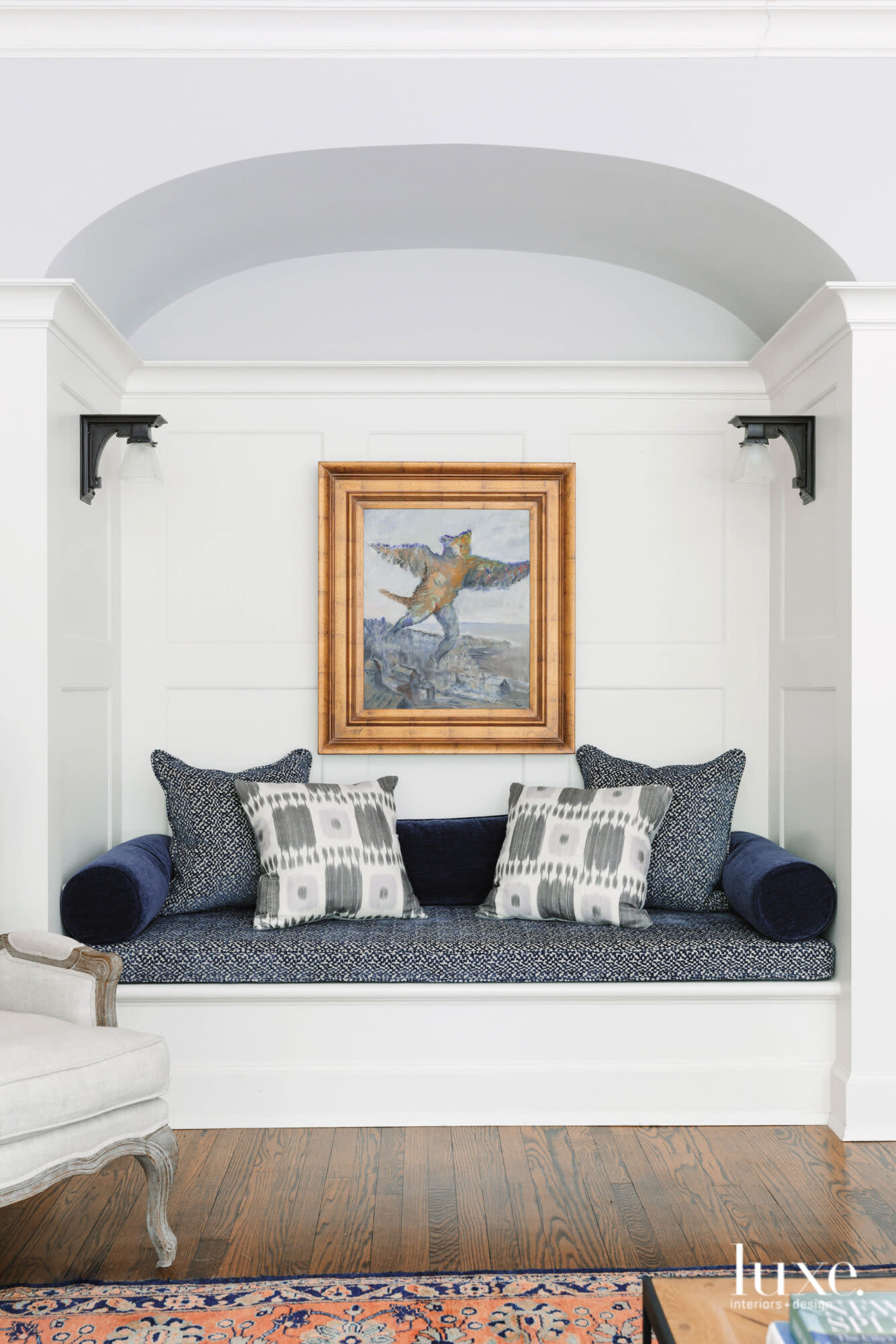 Navy blue fabrics adorn a cozy reading nook bench in the living room