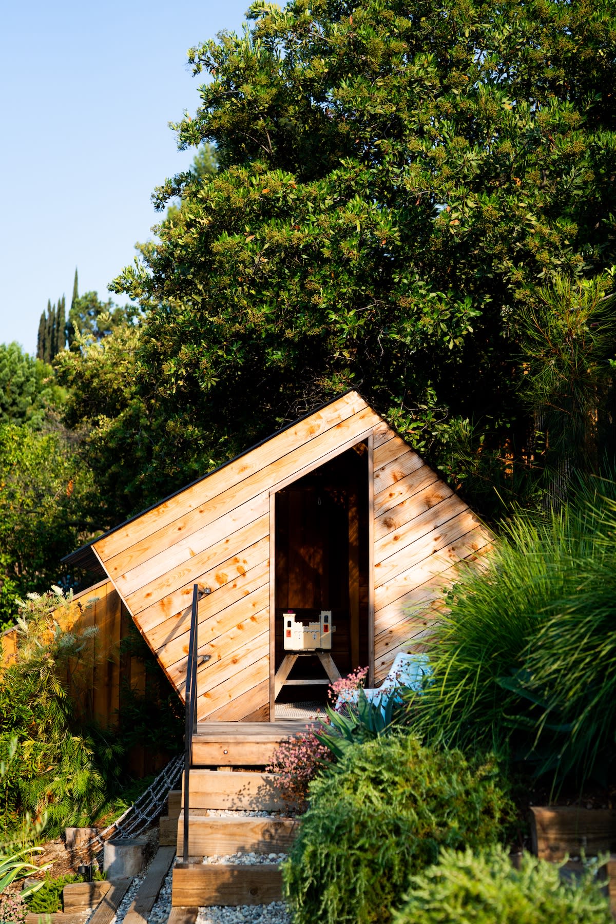 A quaint wooden cabin surrounded by greenery, showcasing a simple design and natural materials