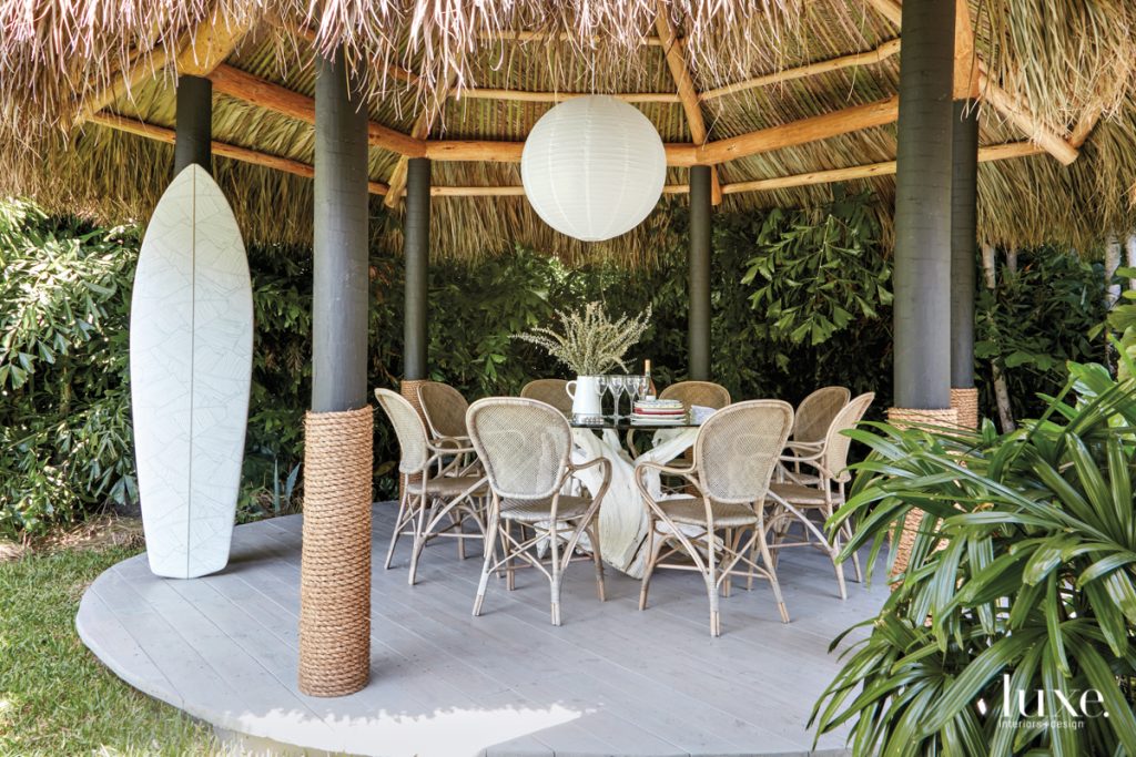 outdoor dining table with globe pendant under tiki