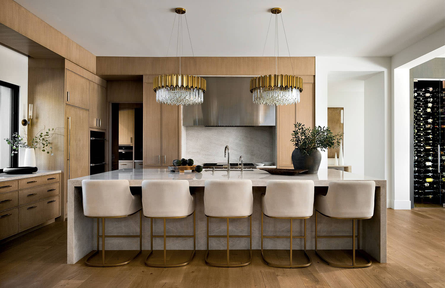 subtle glam kitchen with a large island topped by matching custom chandeliers