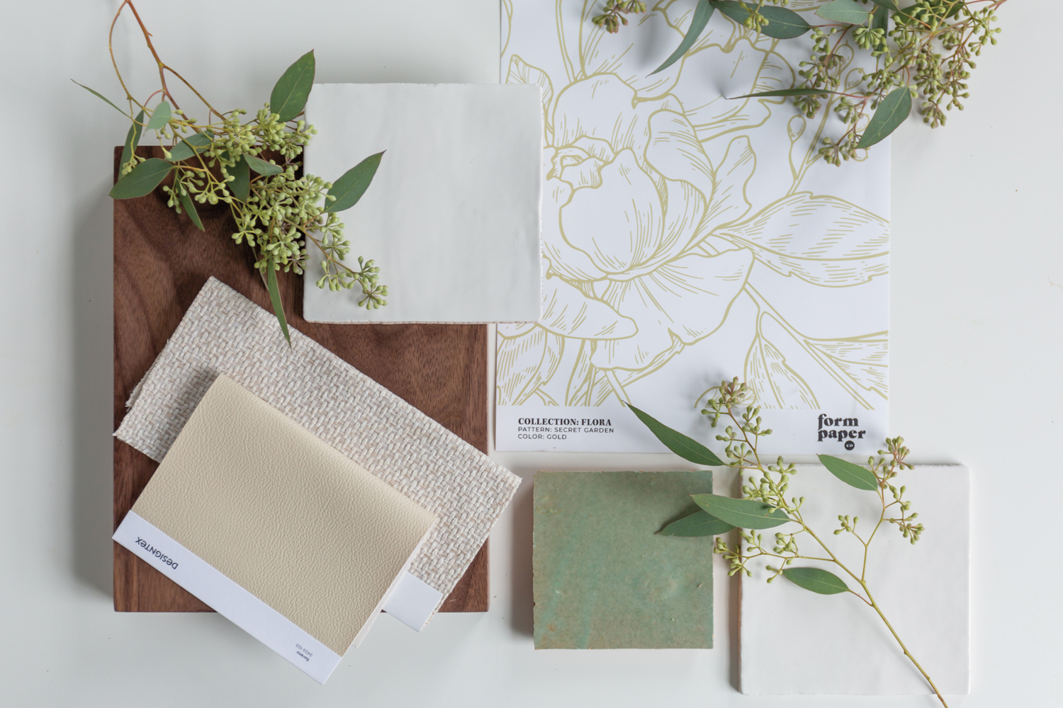 Floral wallpaper swatch with coordinating wood, stone and fabric samples.