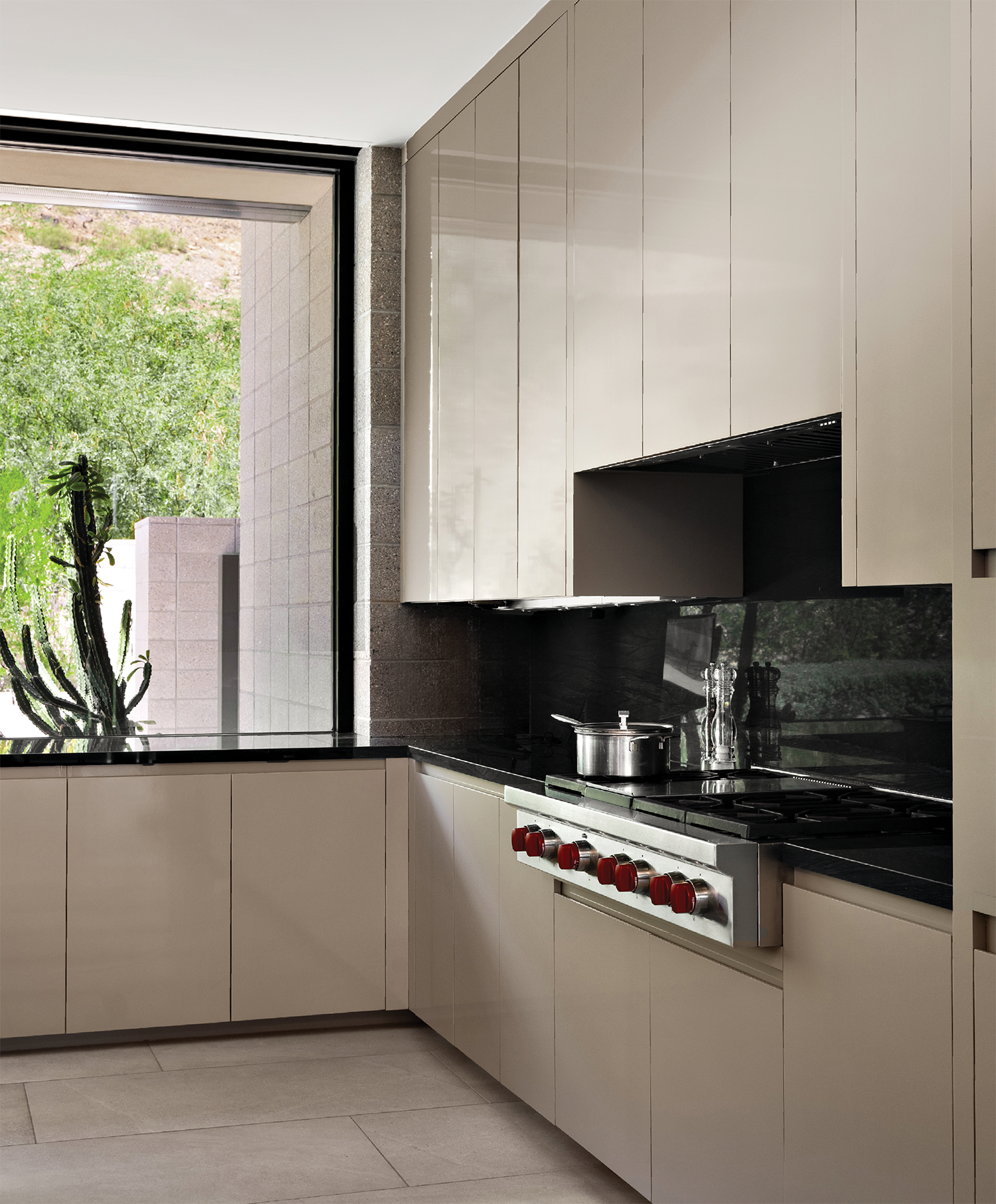 contemporary kitchen with off-white cabinetry and a Wolf stove