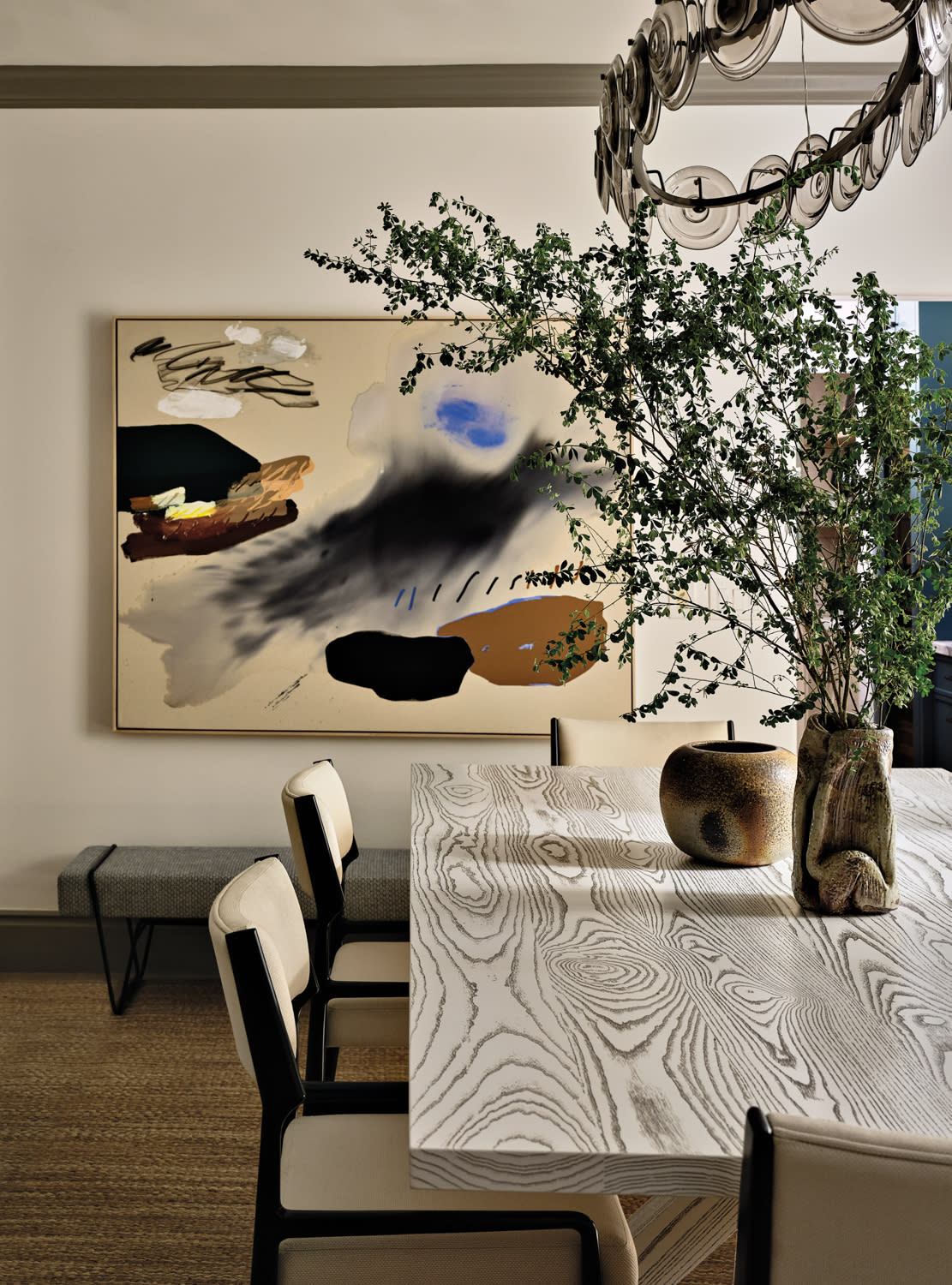 modern dining room with an abstract artwork on the wall behind the dining table