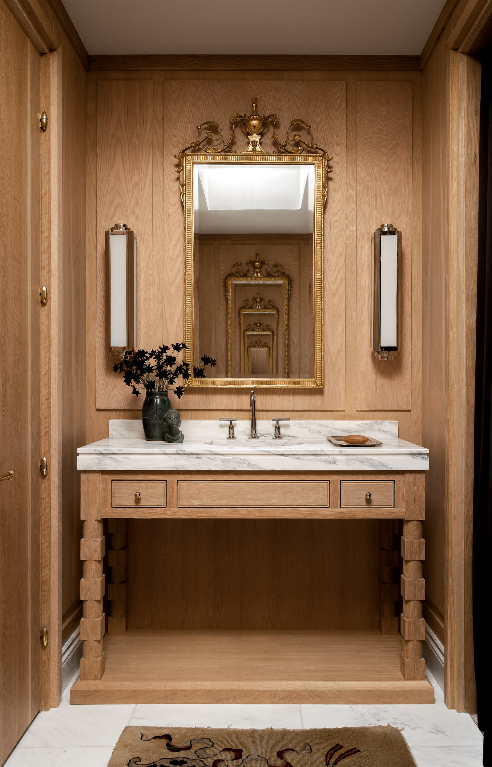 white oak vanity and matching walls inside a Paris-inspired powder room