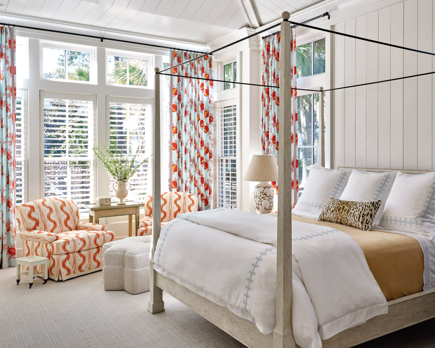 light and bright bedroom with a four poster bed and colorful draperies