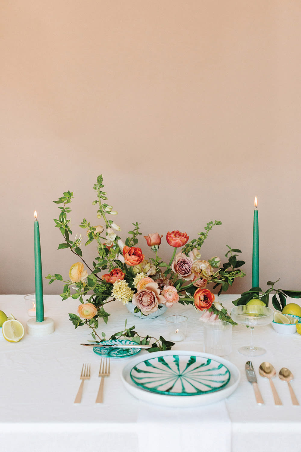 Tablescape with green candles and red, pink and yellow florals.