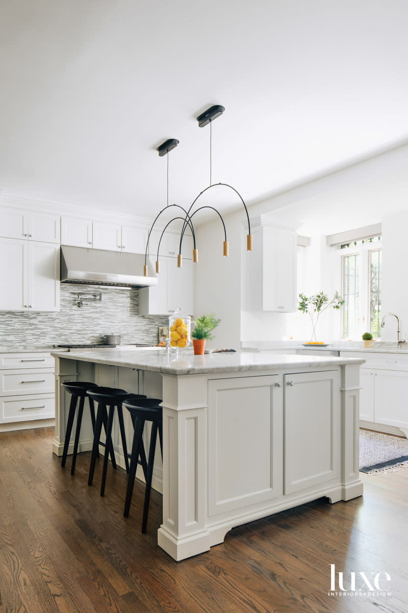 A white kitchen with marble countertops.