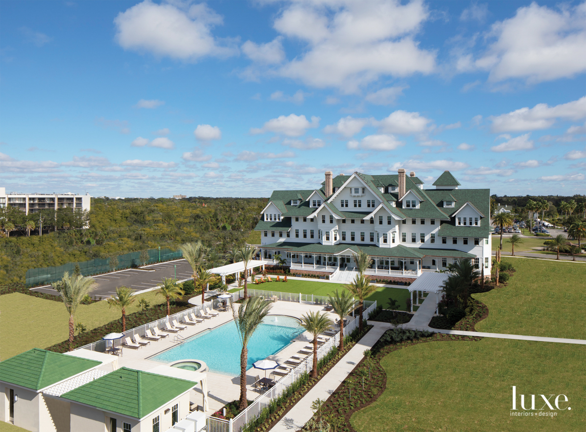 exterior view of green and white inn with pool