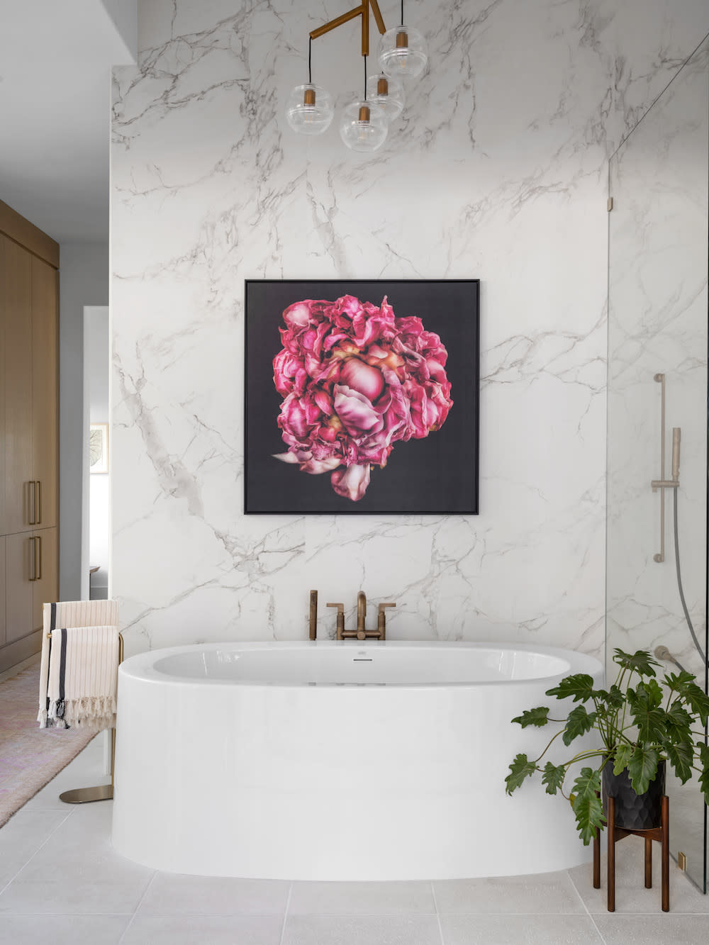 Porcelain Bathroom with pink flower wall art and gold fixtures by Construction Resources in Georgia