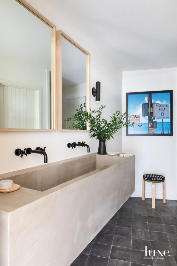 Hart Concrete Design fabricated the guest bathroom's vanity with an integrated sink. The faucets are from Ferguson. Tile flooring by CleÌ adds another textural dimension. Lighting the space is a Workstead sconce. Clasen had the photo, taken by a family member, blown up and framed by Best Framing.
