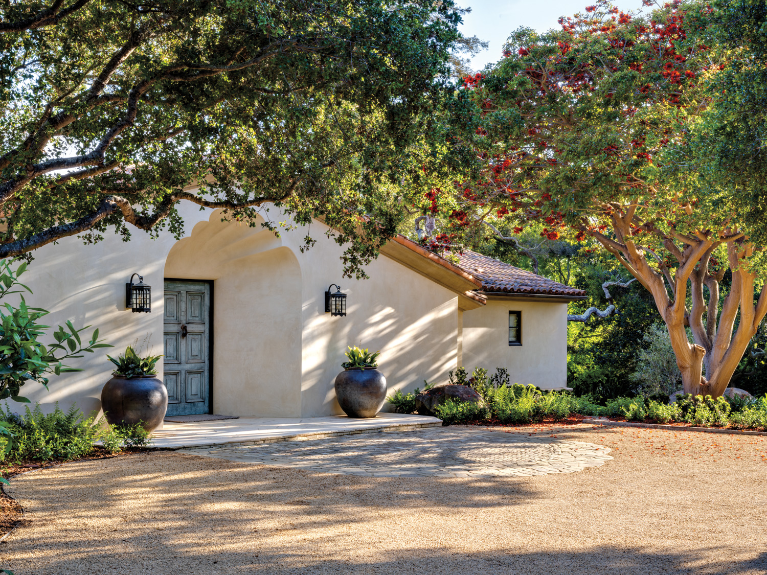 exterior of a Mediterranean-style home with trees at the entrance