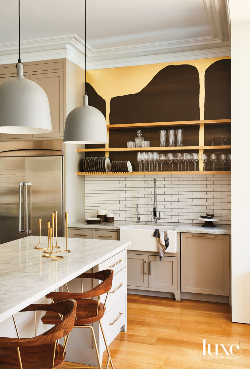 A modern wallpaper with amorphous black shapes lines the wall in back of open kitchen shelves.