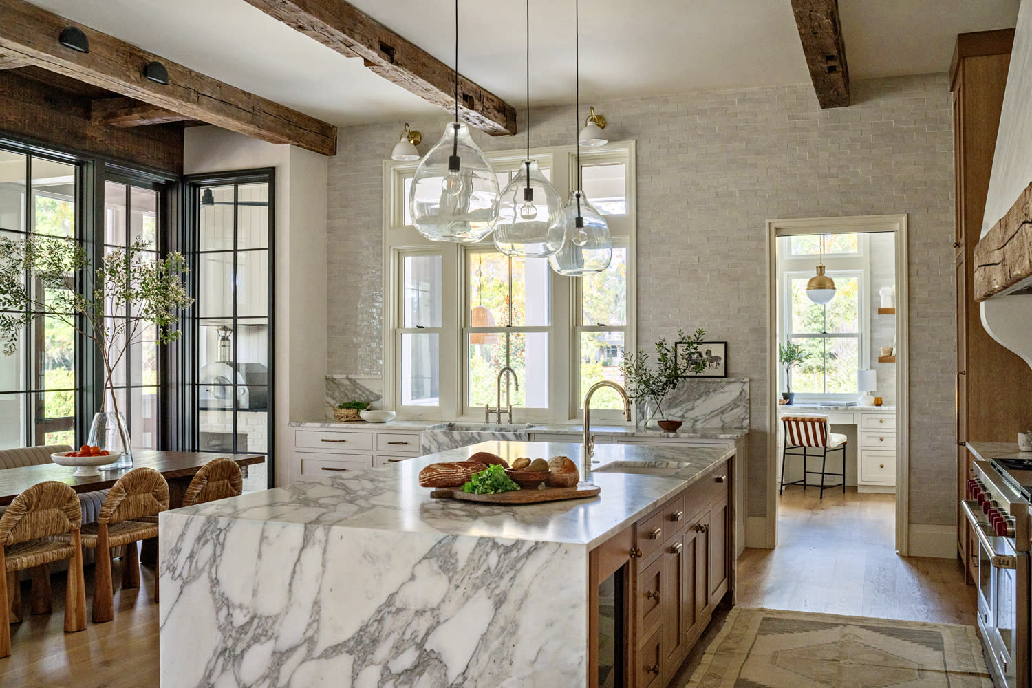 kitchen with marble countertops, walls of zellige tile and limestone, add reclaimed beams above