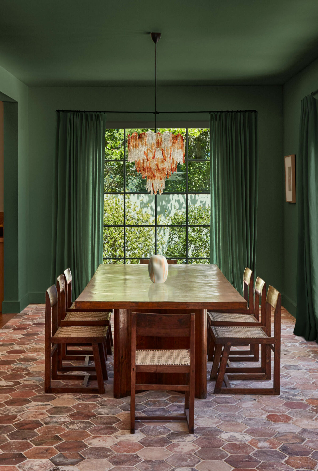 green dining room with brick-colored hexagonal tile flooring