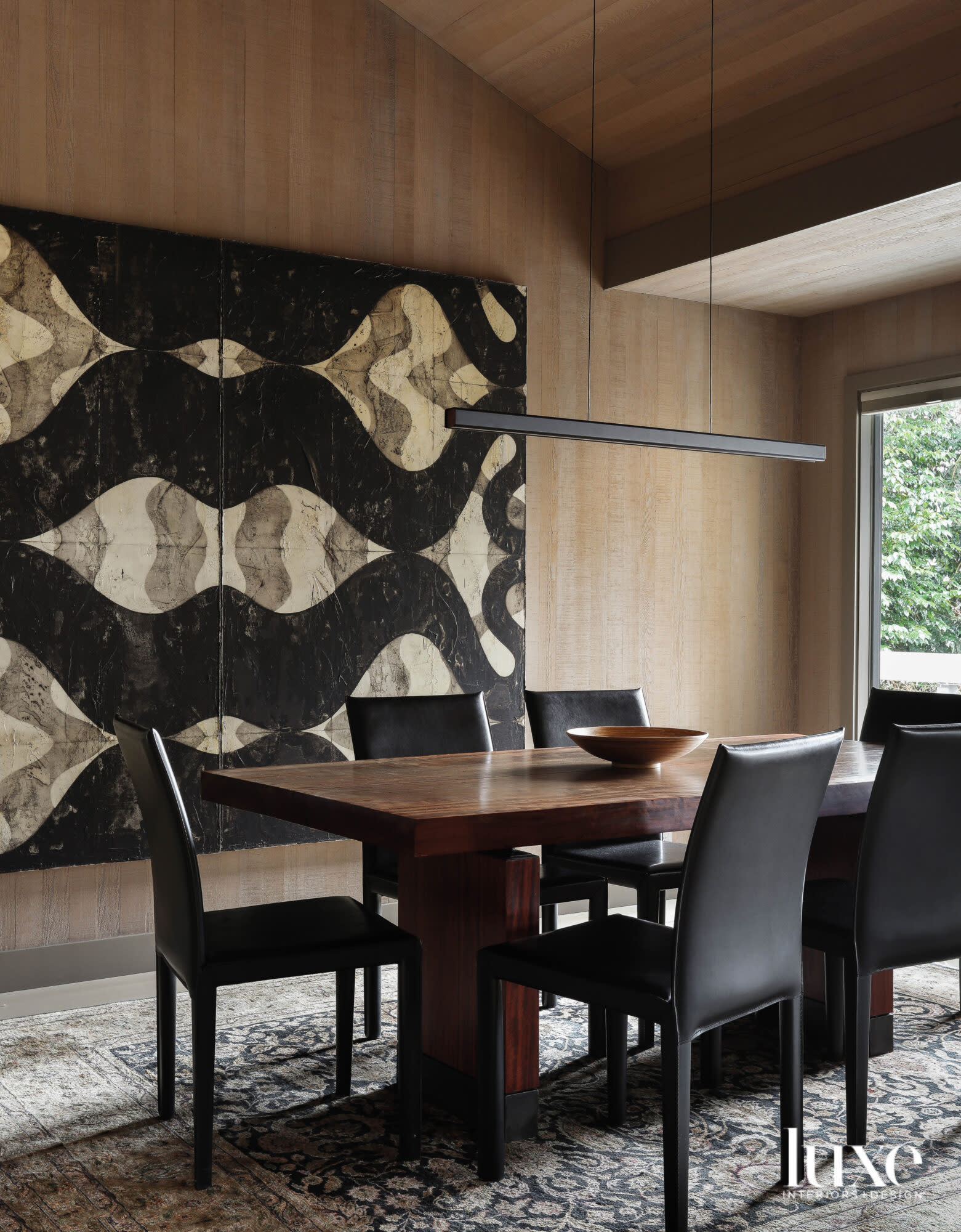 Dining room table and chairs with large artwork behind