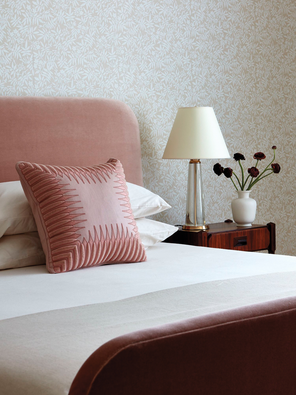 bedroom with tan and white floral wallpaper and a pink upholstered bed