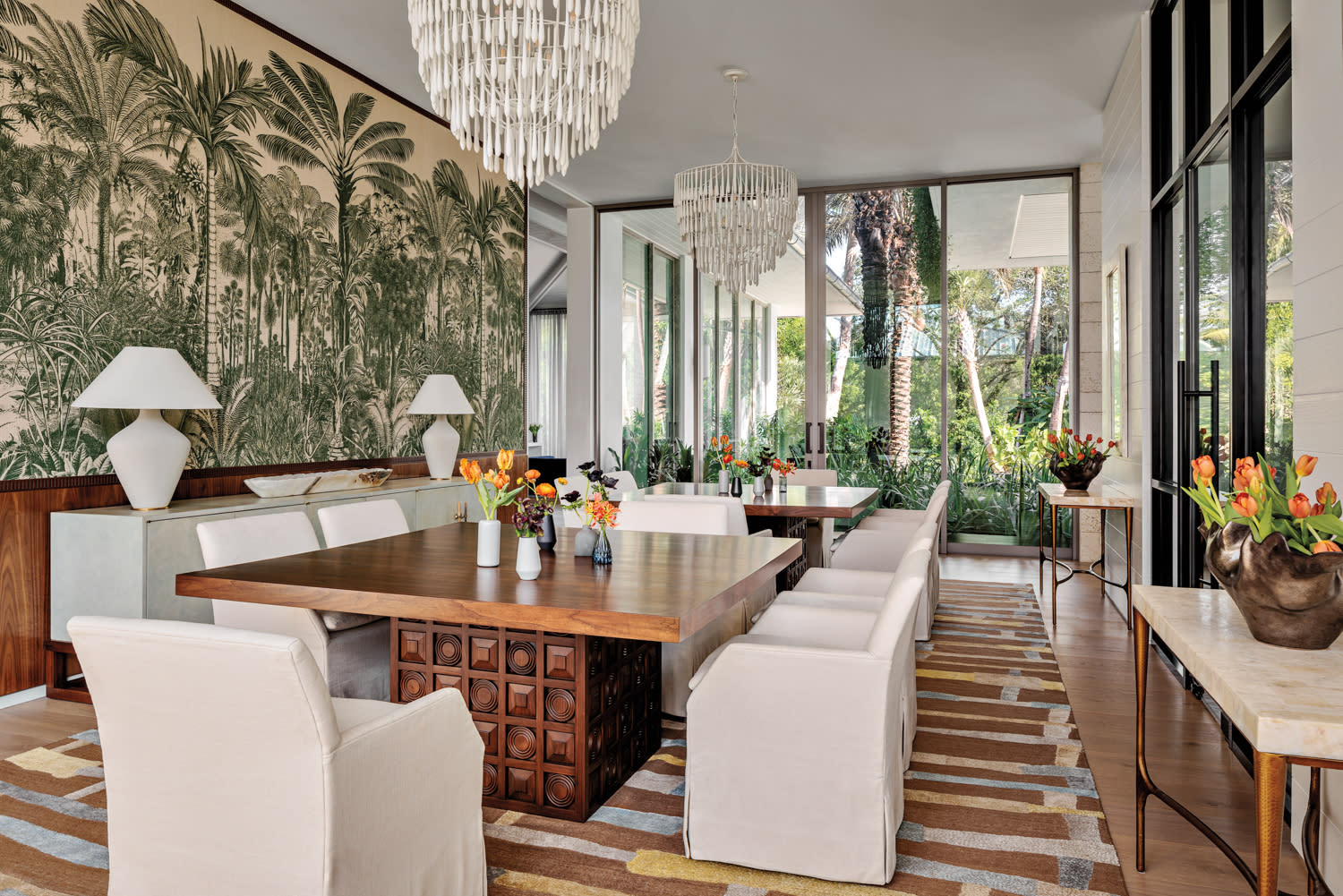 modern Miami dining room with a tropical wallcovering and white dripping chandeliers