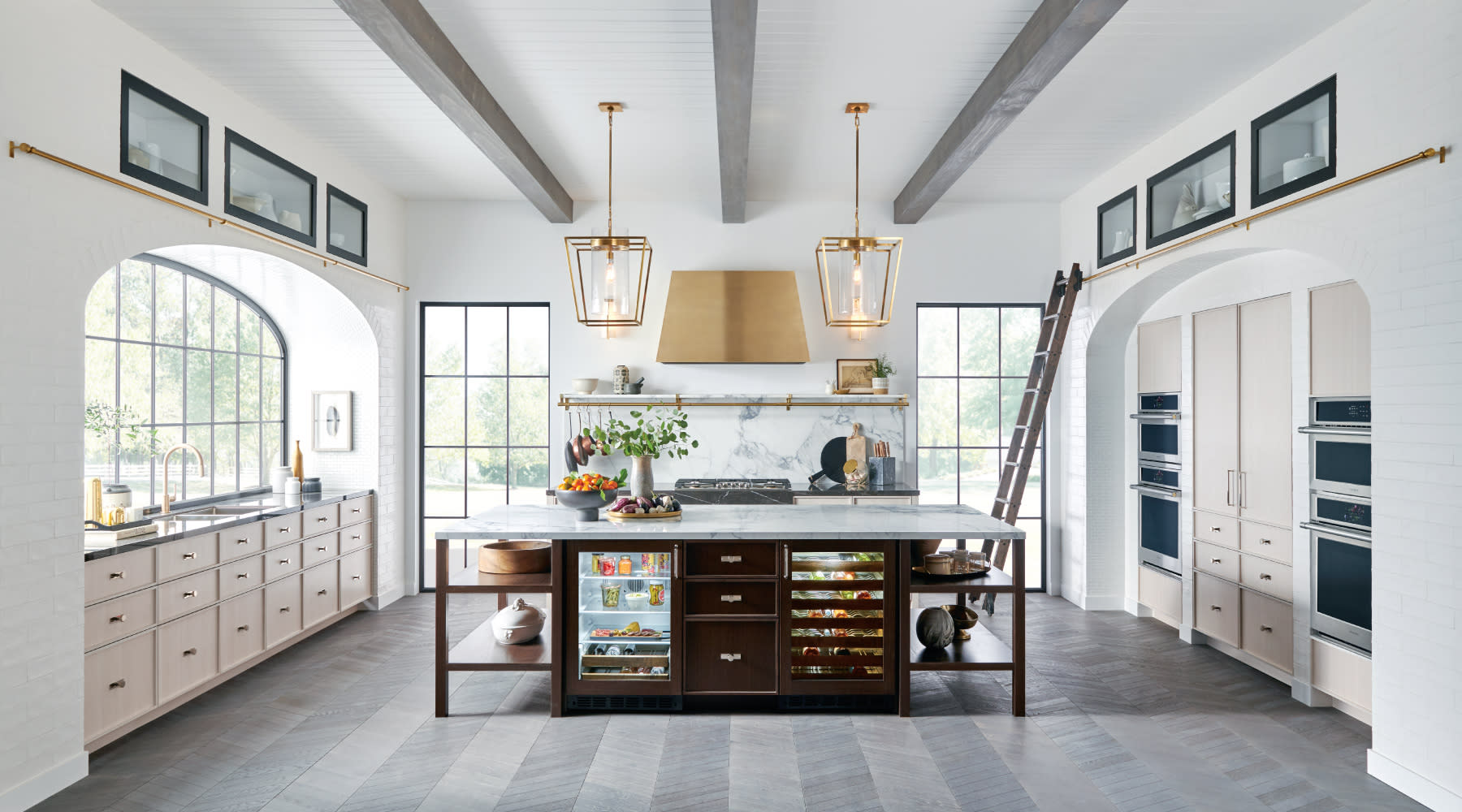 A spacious kitchen showcasing white cabinetry and rich wood flooring, blending elegance with comfort.