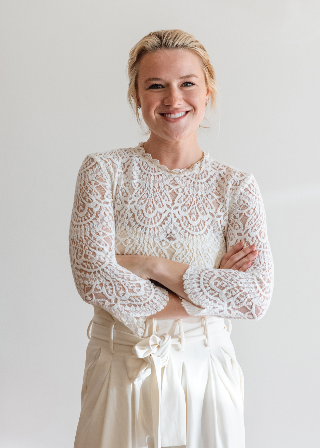 Alexandra Killion wearing all white with her arms folded.