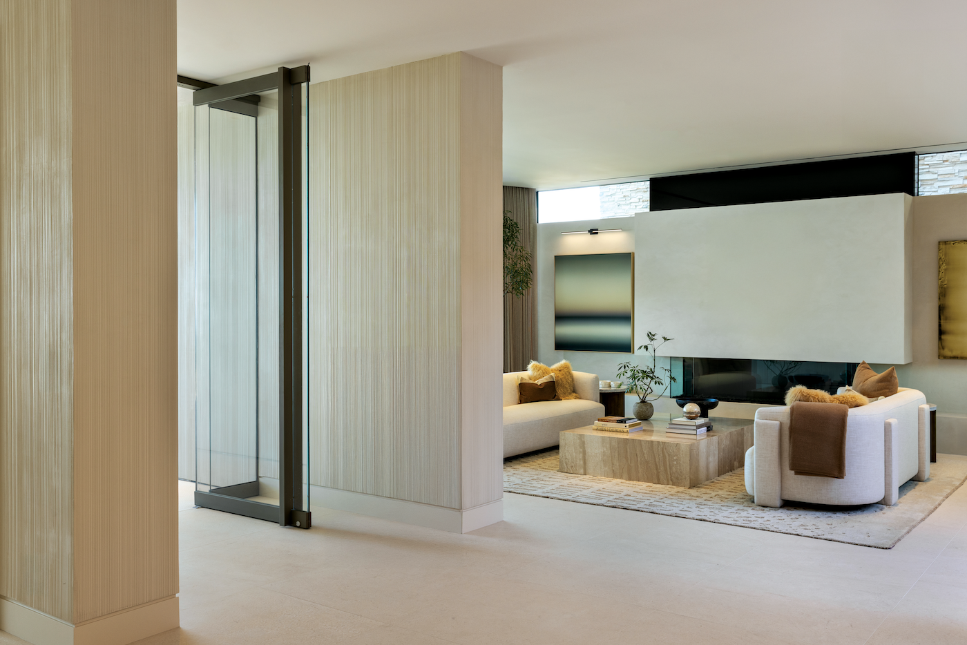 Entryway with custom fluted plaster walls, matte Venetian fireplace, and curated artwork.