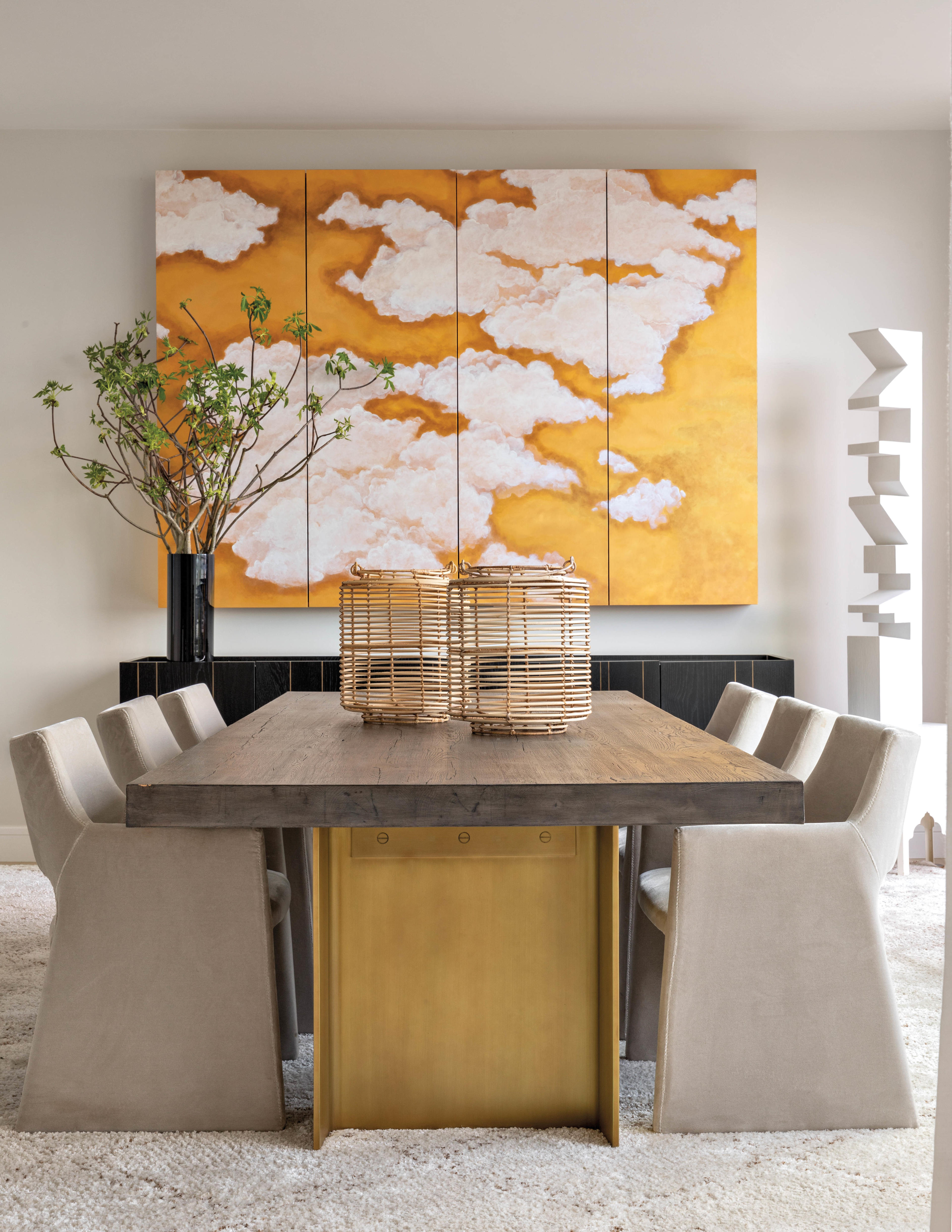 modern dining room with neutral table and yellow cloud art 