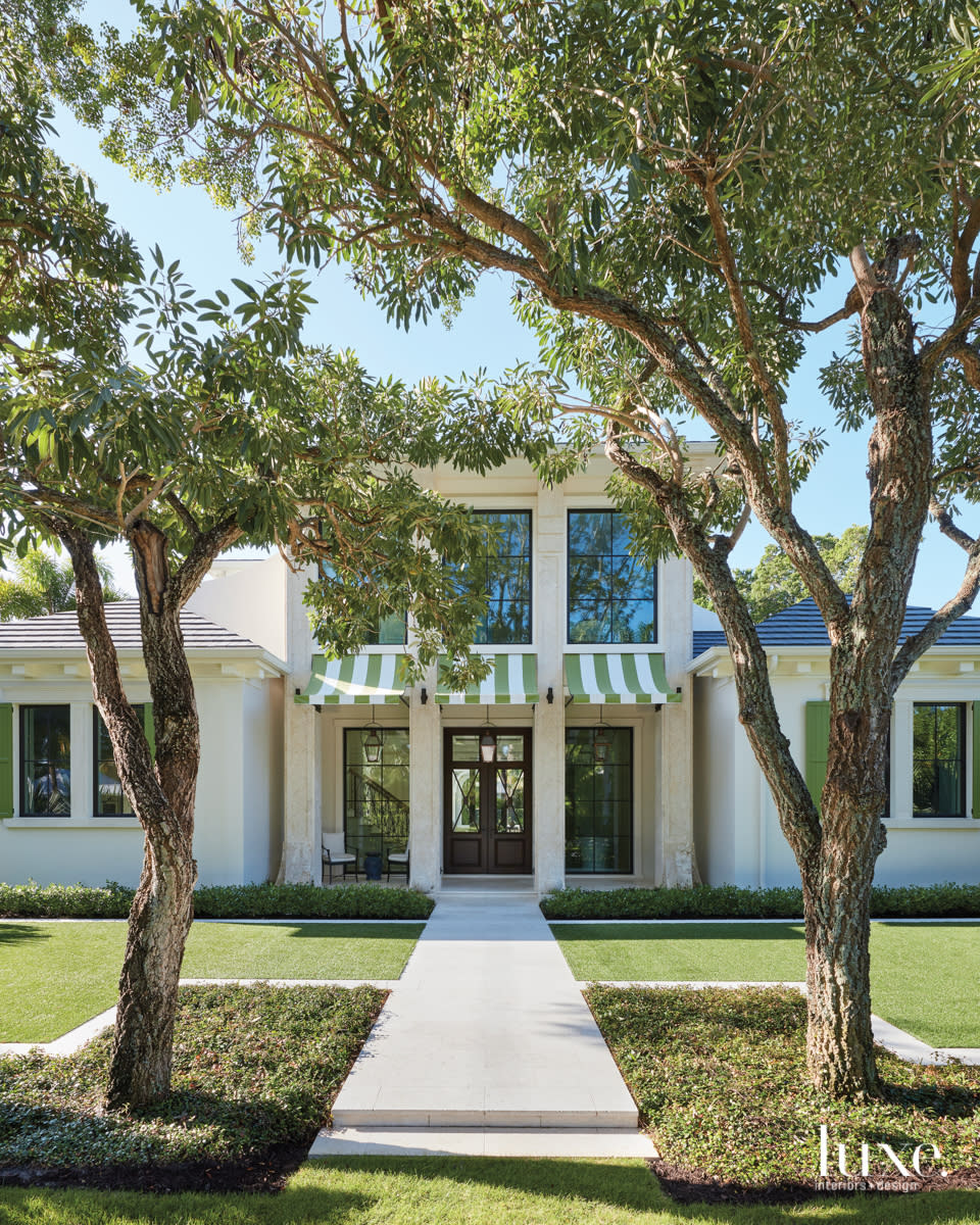 naples home exterior with stripped green awnings