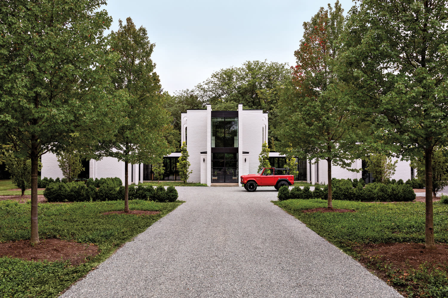 front of white house with red car in driveway