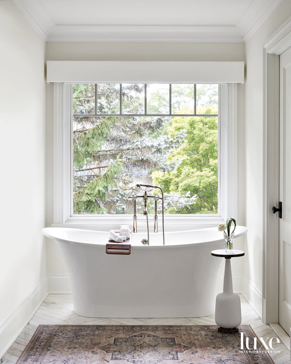 transitional bathroom features white standalone bathtub