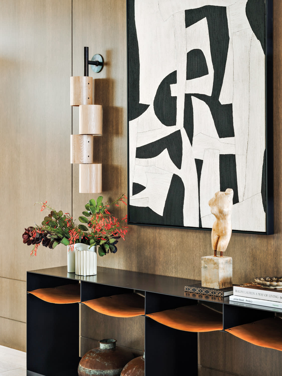 contemporary entryway with a black and white abstract art piece atop wood paneling