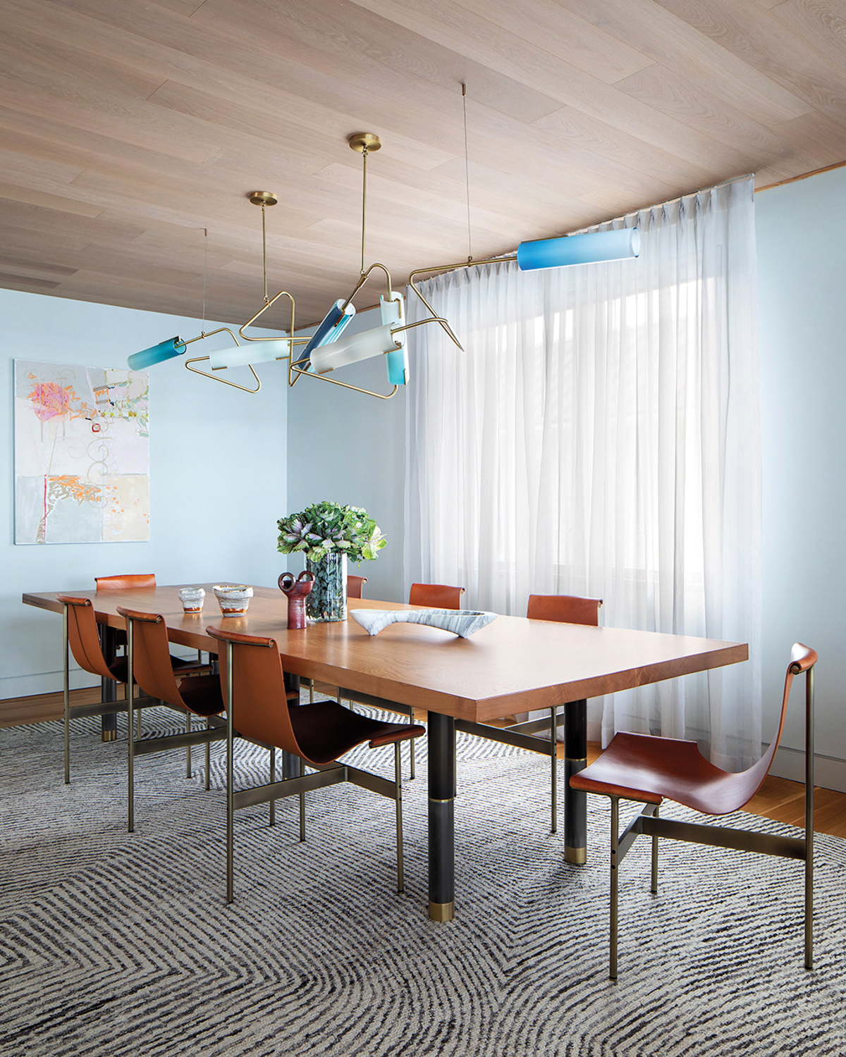 Contemporary luminaire hanging above a long dining table.