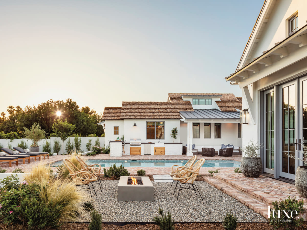 backyard exterior featuring a fire place, outside grill and bar and pool