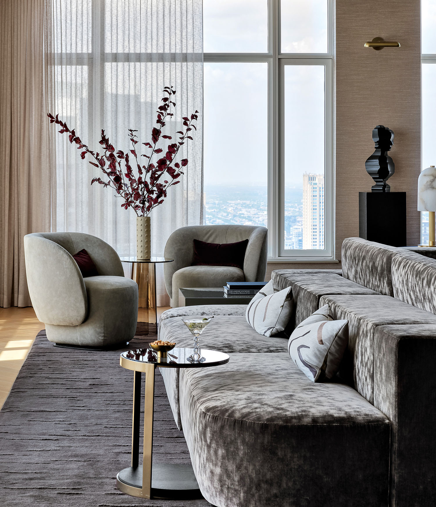 Luxurious living room with large windows, sheer curtains, and plush velvet sofa