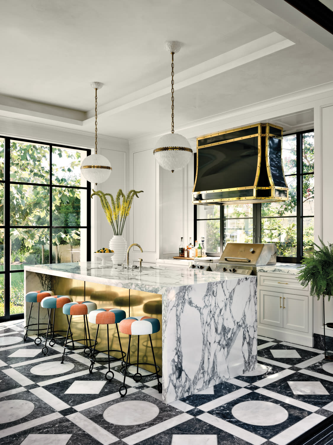 modern pool house with a marble waterfall island and brass insets