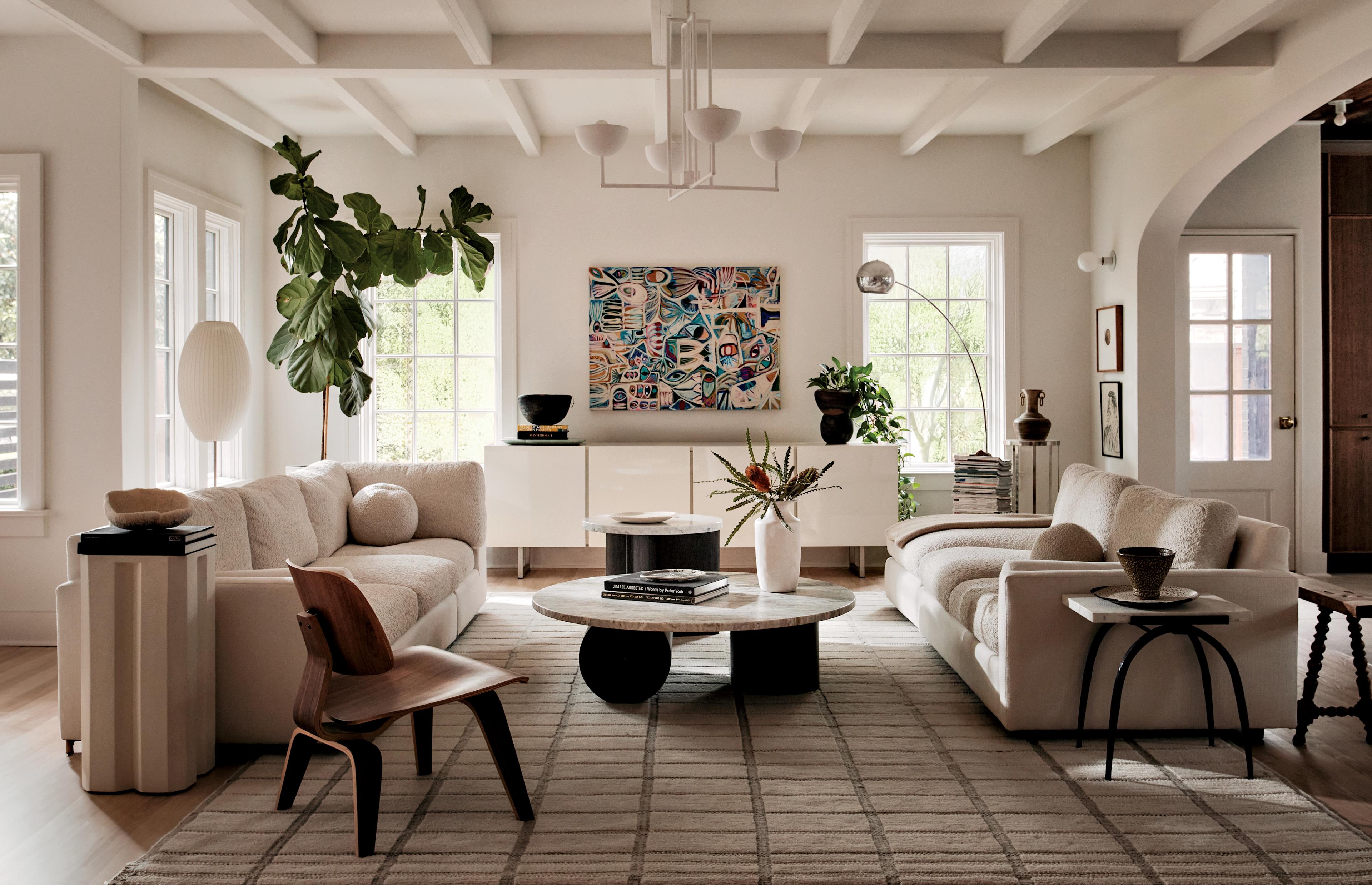 Sofas face each other near an arching floor light, with a chandelier over the coffee table.