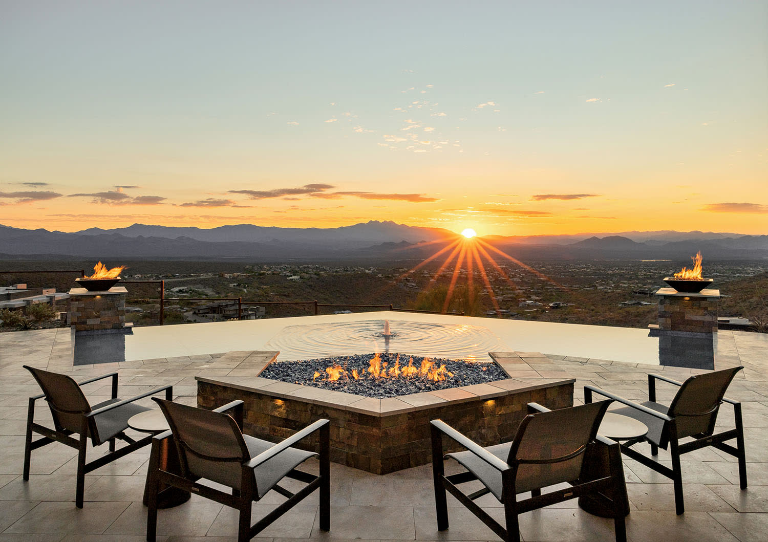 A cozy patio featuring several chairs arranged around a central fire pit, ideal for gatherings and relaxation.