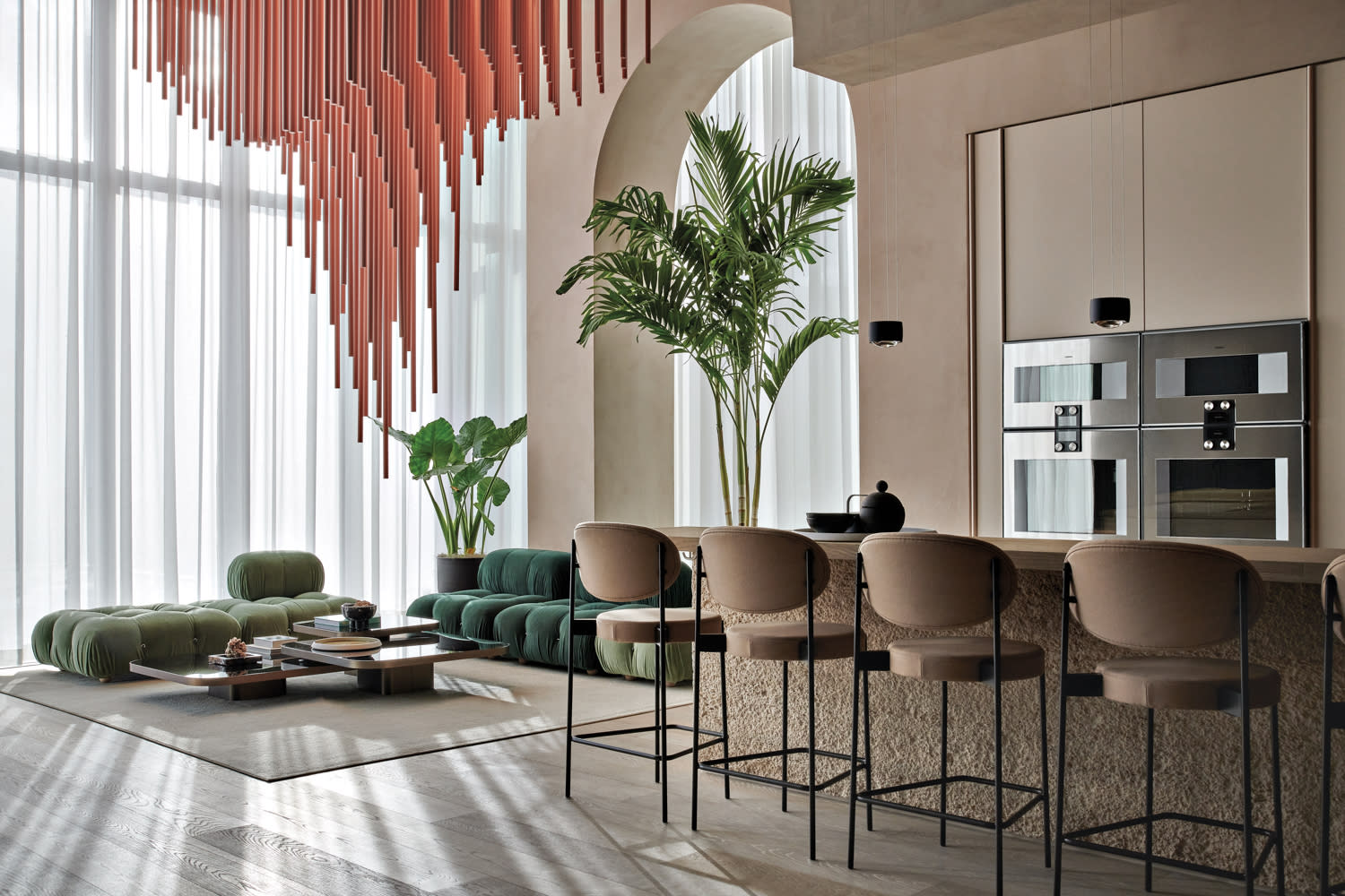 kitchen bar adjacent to a seating area underneath a red orange hanging installation