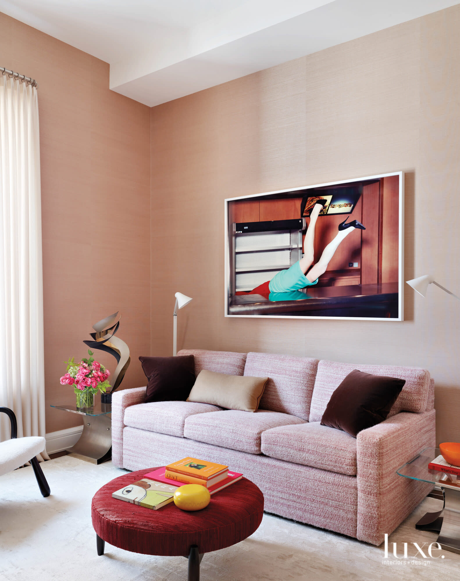 The color pink takes center stage as the sofa and wall color in this office space