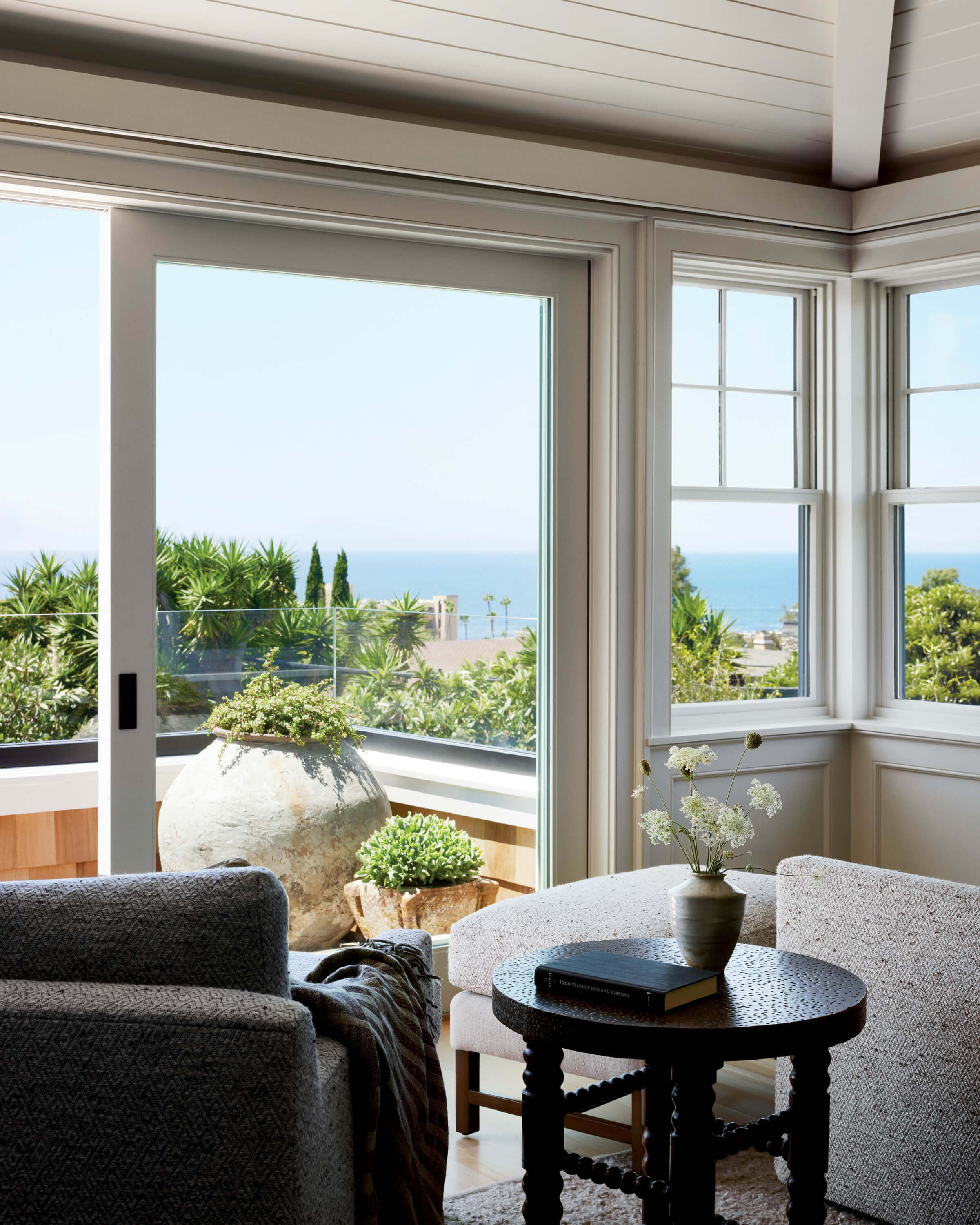 oceanview bedroom seating area with swivel chairs and an ottoman